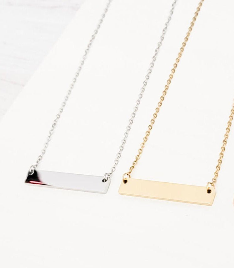 Two necklaces with horizontal bars in silver and gold on a white background