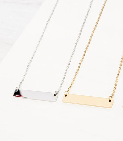 Two necklaces with horizontal bars in silver and gold on a white background