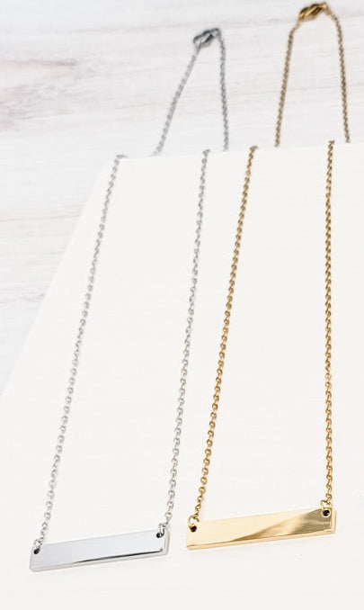 two necklaces in silver and gold on a white surface.